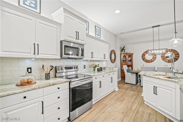 8608 Via Rapallo Dr Unit 206, Estero, FL 33928 - kitchen featuring stainless steel appliances, backsplash, white cabinetry, and recessed lighting