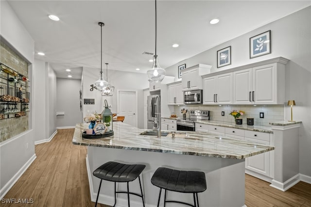 8608 Via Rapallo Dr Unit 206, Estero, FL 33928 - kitchen featuring stainless steel appliances, a breakfast bar, backsplash, white cabinetry, and recessed lighting