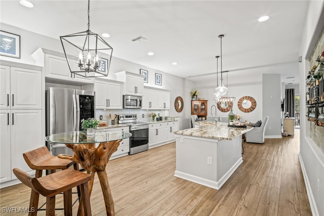 8608 Via Rapallo Dr Unit 206, Estero, FL 33928 - kitchen featuring appliances with stainless steel finishes, a chandelier, white cabinetry, light wood-type flooring, and recessed lighting