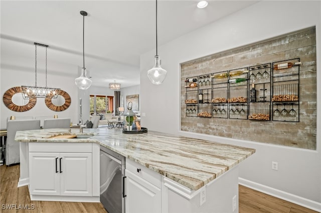 8608 Via Rapallo Dr Unit 206, Estero, FL 33928 - kitchen with stainless steel dishwasher, a chandelier, white cabinetry, and light stone counters