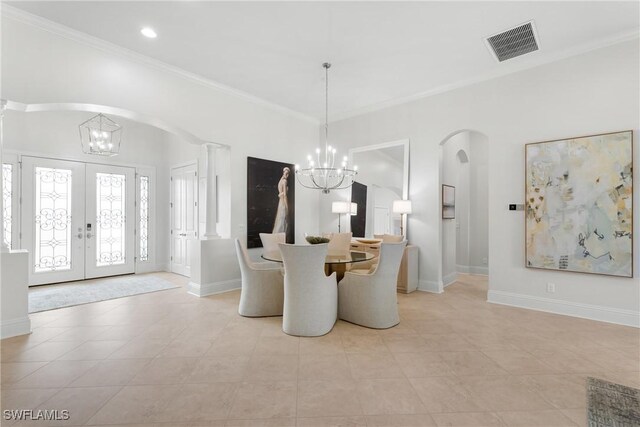 8888 Savona Ct, Naples, FL 34119 - dining space featuring a chandelier, arched walkways, ornamental molding, french doors, and light tile patterned flooring