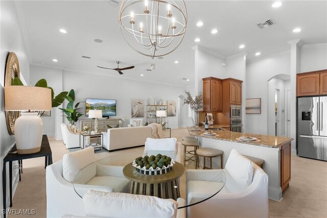 8888 Savona Ct, Naples, FL 34119 - dining space with crown molding, arched walkways, a chandelier, lofted ceiling, and light tile patterned floors