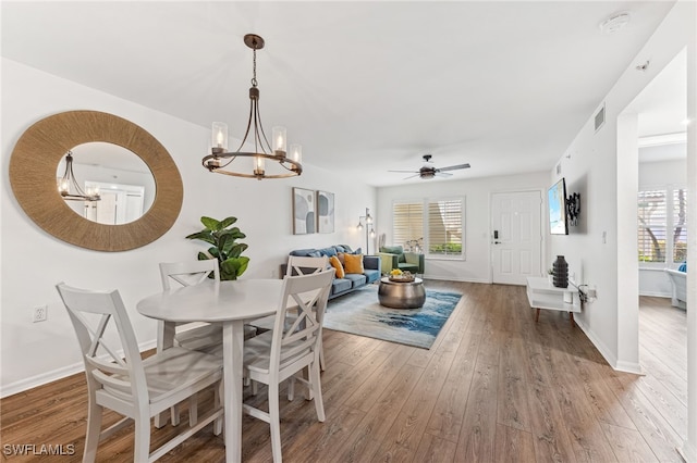 4940 Cougar Ct S Unit 104, Naples, FL 34109 - dining room featuring a chandelier, wood-type flooring, ceiling fan, and plenty of natural light