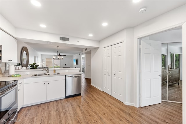 4940 Cougar Ct S Unit 104, Naples, FL 34109 - kitchen with appliances with stainless steel finishes, a peninsula, light wood-type flooring, white cabinets, and light countertops