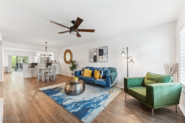 4940 Cougar Ct S Unit 104, Naples, FL 34109 - living area featuring hardwood / wood-style flooring, ceiling fan, and a chandelier
