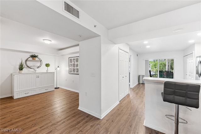 4940 Cougar Ct S Unit 104, Naples, FL 34109 - kitchen with wood finished floors, radiator, and recessed lighting