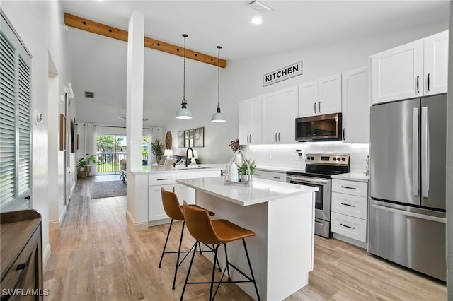 162 Pebble Shores Dr Unit 203, Naples, FL 34110 - kitchen featuring appliances with stainless steel finishes, a peninsula, tasteful backsplash, light countertops, and a kitchen bar