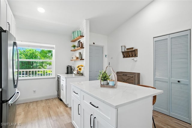 162 Pebble Shores Dr Unit 203, Naples, FL 34110 - kitchen with freestanding refrigerator, a kitchen island, light wood finished floors, open shelves, and white cabinetry