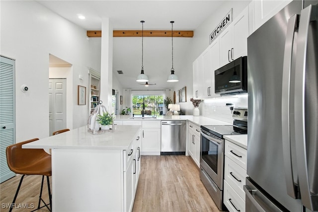162 Pebble Shores Dr Unit 203, Naples, FL 34110 - kitchen with appliances with stainless steel finishes, light wood-type flooring, a kitchen bar, beam ceiling, and white cabinets