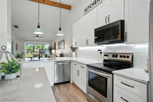162 Pebble Shores Dr Unit 203, Naples, FL 34110 - kitchen with appliances with stainless steel finishes, backsplash, white cabinets, and hanging light fixtures