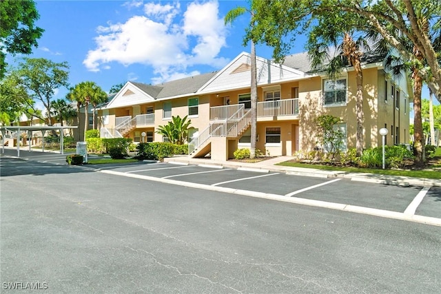 162 Pebble Shores Dr Unit 203, Naples, FL 34110 - view of property with stairway and uncovered parking