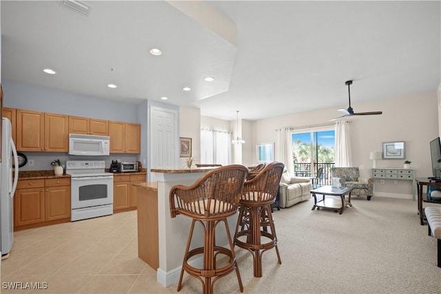 3724 Agualinda Blvd Unit 201, Cape Coral, FL 33914 - kitchen with white appliances, a breakfast bar, open floor plan, light brown cabinetry, and ceiling fan