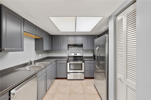 3140 Seasons Way Unit 510, Estero, FL 33928 - kitchen with stainless steel appliances, under cabinet range hood, light tile patterned floors, dark countertops, and gray cabinets