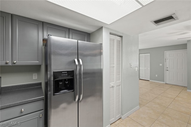 3140 Seasons Way Unit 510, Estero, FL 33928 - kitchen with stainless steel fridge, gray cabinets, dark countertops, and light tile patterned floors