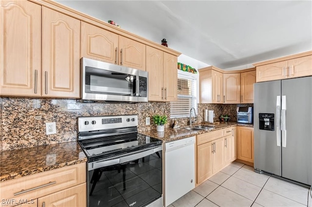 2200 50th St SW, Naples, FL 34116 - kitchen featuring stainless steel appliances, light brown cabinetry, dark stone counters, and decorative backsplash