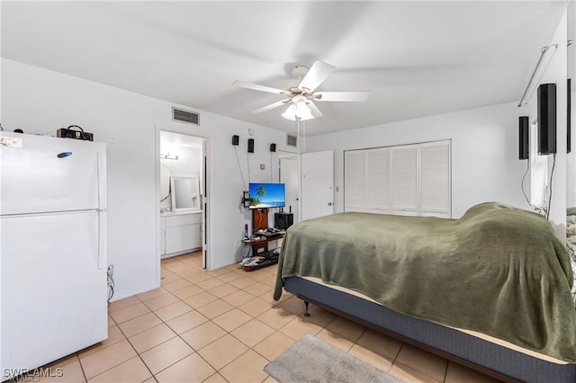 2200 50th St SW, Naples, FL 34116 - bedroom with freestanding refrigerator, light tile patterned flooring, a ceiling fan, and ensuite bathroom