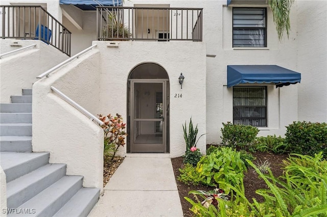 3313 Europa Dr Unit 214, Naples, FL 34105 - property entrance with stucco siding and a balcony