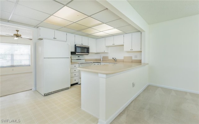 6884 Sandtrap Dr Unit 4, Fort Myers, FL 33919 - kitchen featuring white appliances, light countertops, a peninsula, a drop ceiling, and light colored carpet