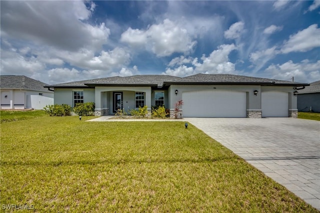 506 NE 2nd Place, Cape Coral, FL 33909 - view of front of property featuring decorative driveway, stucco siding, an attached garage, a front lawn, and stone siding