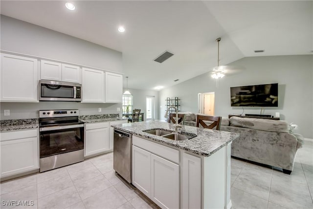 506 NE 2nd Place, Cape Coral, FL 33909 - kitchen featuring stainless steel appliances, lofted ceiling, white cabinets, light stone counters, and a ceiling fan