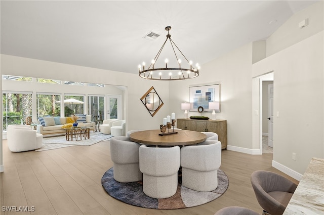 211 11th St NW, Naples, FL 34120 - dining space featuring a chandelier, wood finished floors, and lofted ceiling