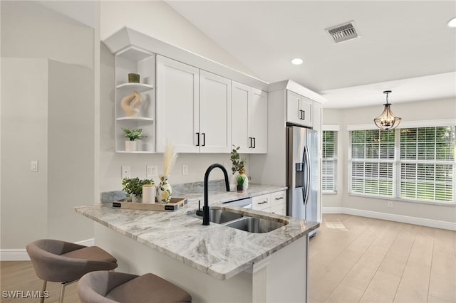 211 11th St NW, Naples, FL 34120 - kitchen featuring stainless steel fridge with ice dispenser, open shelves, white cabinetry, light stone countertops, and pendant lighting