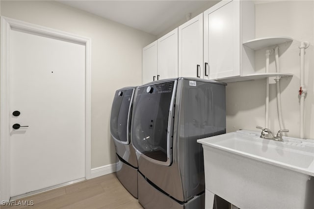 211 11th St NW, Naples, FL 34120 - laundry room with washing machine and clothes dryer, cabinet space, and light wood finished floors