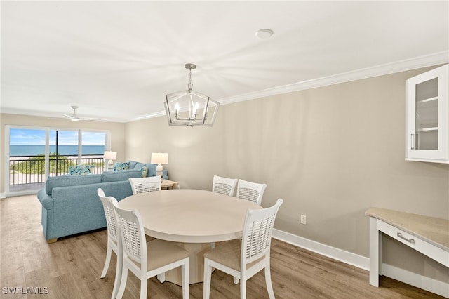 3067 W Gulf Dr Unit 102, Sanibel, FL 33957 - dining room with light wood-type flooring, a chandelier, crown molding, and a water view