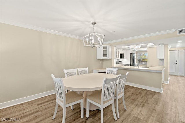 3067 W Gulf Dr Unit 102, Sanibel, FL 33957 - dining area featuring a chandelier, light wood finished floors, and crown molding