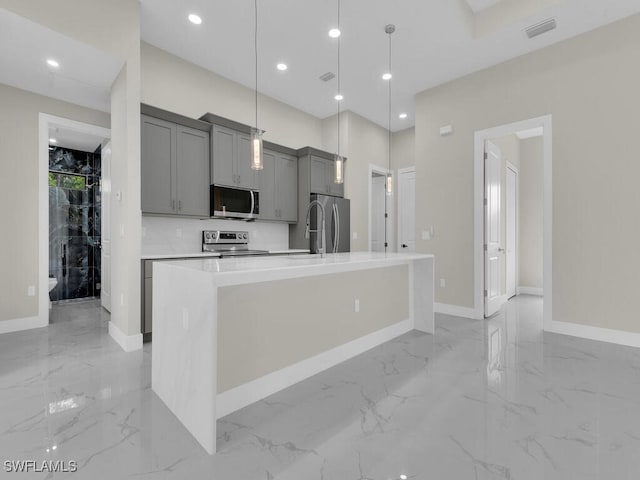 410 Plumosa Ave, Lehigh Acres, FL 33972 - kitchen with appliances with stainless steel finishes, gray cabinetry, light marble finish floors, a spacious island, and light countertops