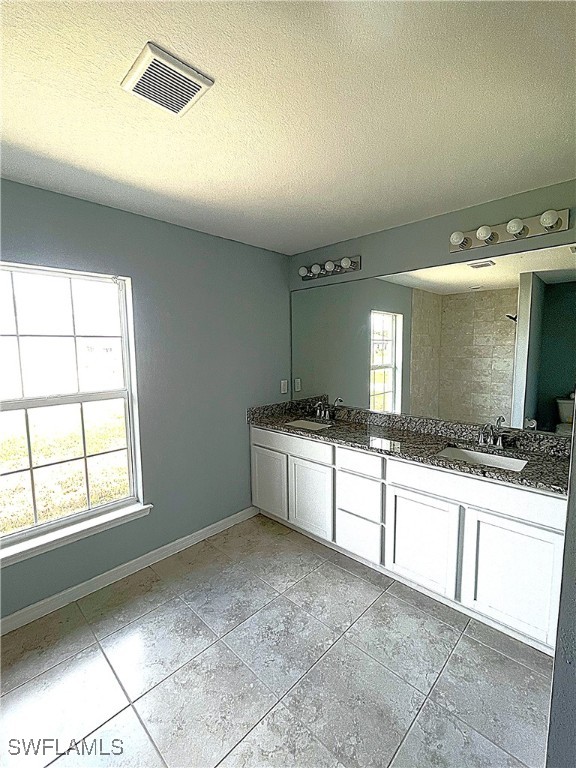 2614 NE 6th Pl, Cape Coral, FL 33909 - bathroom featuring double vanity and a textured ceiling