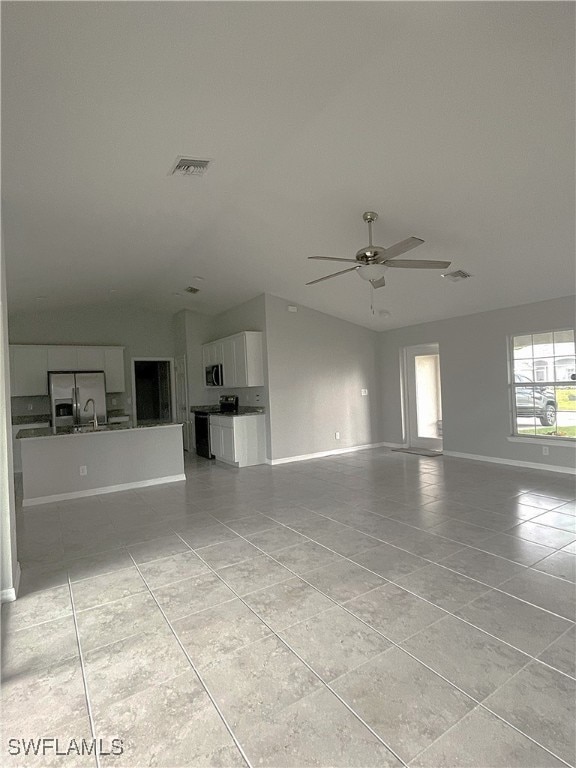 2614 NE 6th Pl, Cape Coral, FL 33909 - unfurnished living room featuring light tile patterned flooring, lofted ceiling, and a ceiling fan