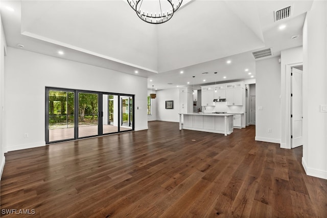 3708 Stagg Ct, Fort Myers, FL 33905 - unfurnished living room with dark wood finished floors, a chandelier, a high ceiling, and recessed lighting