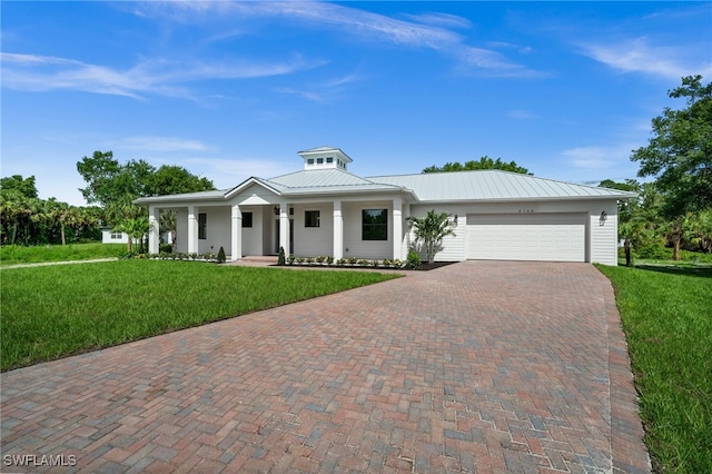 3708 Stagg Ct, Fort Myers, FL 33905 - view of front facade with decorative driveway, an attached garage, covered porch, a standing seam roof, and a front lawn