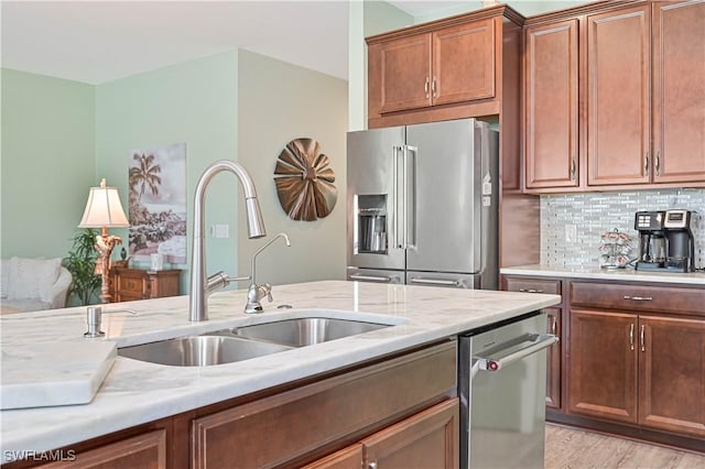 3344 Apple Blossom Dr, Alva, FL 33920 - kitchen with stainless steel appliances, backsplash, light wood-style floors, light stone countertops, and brown cabinets