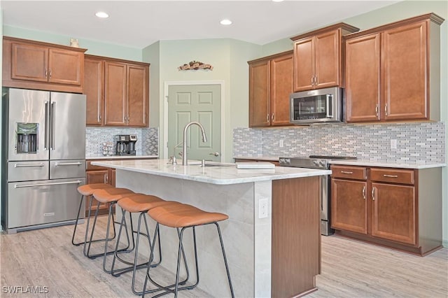 3344 Apple Blossom Dr, Alva, FL 33920 - kitchen featuring appliances with stainless steel finishes, light wood-type flooring, a center island with sink, a breakfast bar area, and recessed lighting