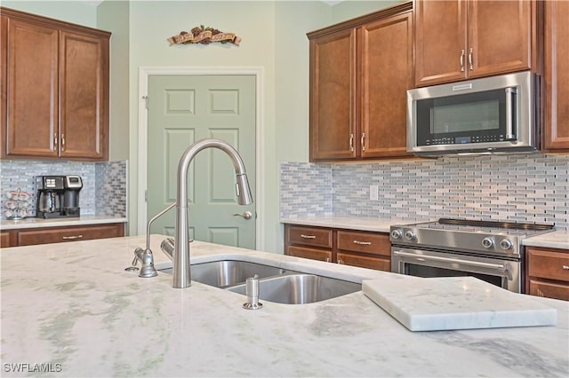 3344 Apple Blossom Dr, Alva, FL 33920 - kitchen featuring stainless steel appliances, light stone countertops, tasteful backsplash, and brown cabinetry