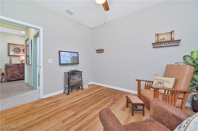 3344 Apple Blossom Dr, Alva, FL 33920 - living area with a wood stove, light wood-style floors, and ceiling fan