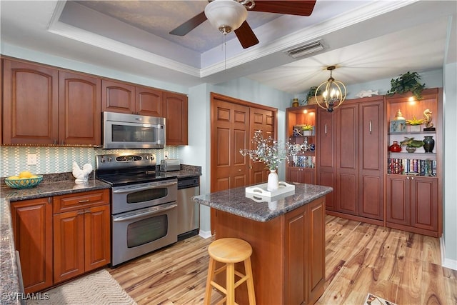 1925 Clifford St Unit 202, Fort Myers, FL 33901 - kitchen with appliances with stainless steel finishes, light wood-type flooring, a center island, and tasteful backsplash