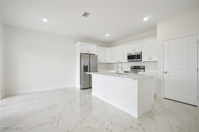 7007 Ramrod Cir, Labelle, FL 33935 - kitchen with stainless steel appliances, light marble finish floors, white cabinetry, a center island with sink, and recessed lighting