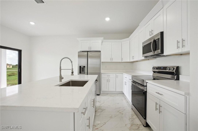 7007 Ramrod Cir, Labelle, FL 33935 - kitchen featuring stainless steel appliances, light marble finish floors, a center island with sink, light countertops, and white cabinets