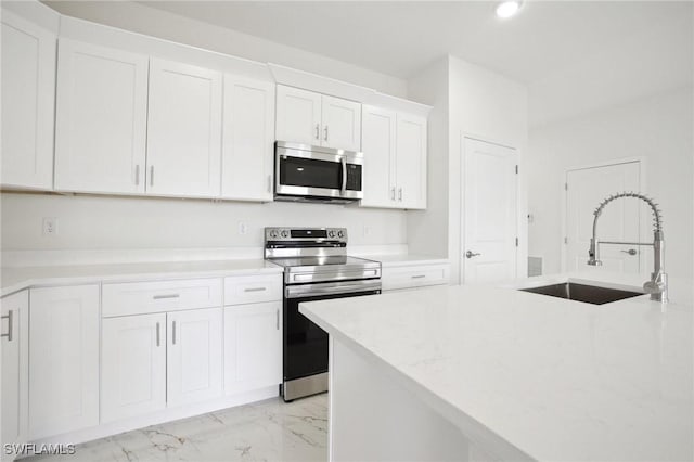 7007 Ramrod Cir, Labelle, FL 33935 - kitchen with appliances with stainless steel finishes, light marble finish flooring, white cabinets, light countertops, and recessed lighting