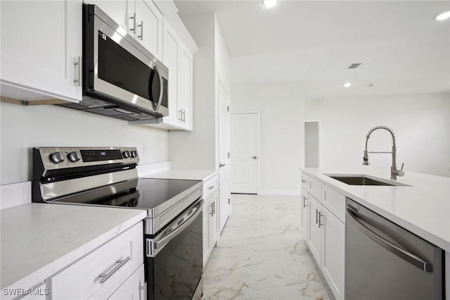 7007 Ramrod Cir, Labelle, FL 33935 - kitchen with stainless steel appliances, light marble finish flooring, recessed lighting, light countertops, and white cabinetry