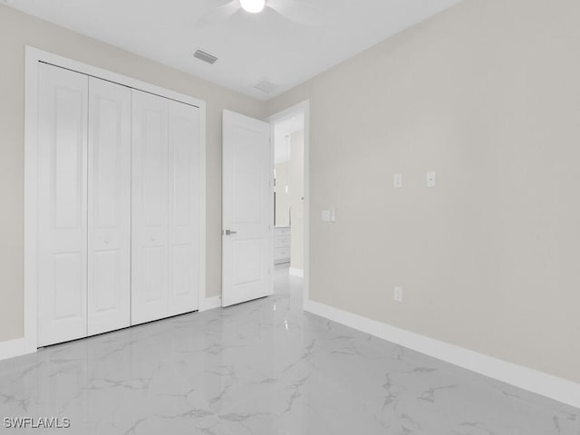 1304 Williams Ave, Lehigh Acres, FL 33972 - unfurnished bedroom featuring marble finish floors, a closet, and ceiling fan