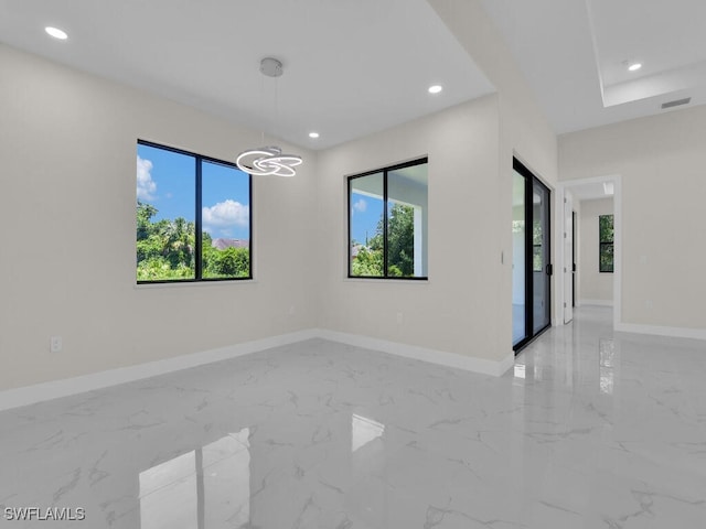 1304 Williams Ave, Lehigh Acres, FL 33972 - unfurnished room featuring light marble finish flooring, healthy amount of natural light, recessed lighting, and a chandelier