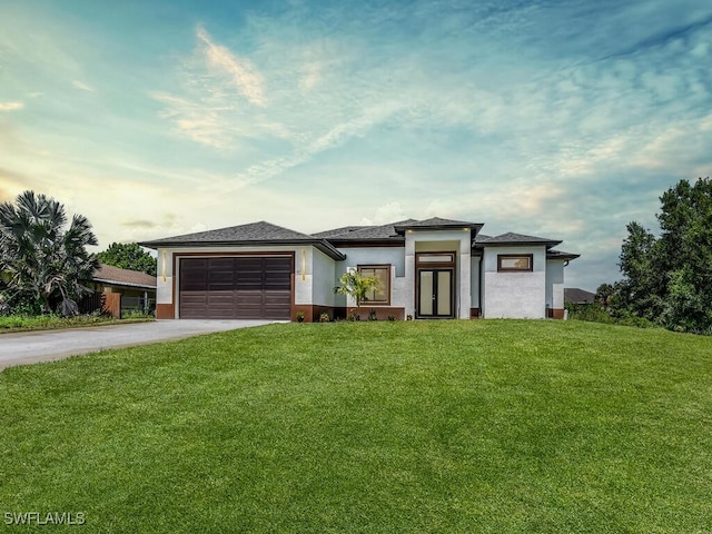 1304 Williams Ave, Lehigh Acres, FL 33972 - prairie-style house with driveway, a garage, a front lawn, and stucco siding