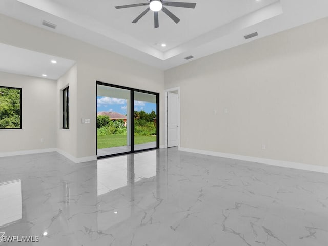 1304 Williams Ave, Lehigh Acres, FL 33972 - empty room with a raised ceiling, plenty of natural light, marble tiled floors, and recessed lighting