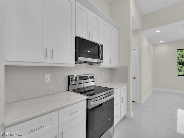 1304 Williams Ave, Lehigh Acres, FL 33972 - kitchen featuring appliances with stainless steel finishes, white cabinetry, light marble finish floors, light countertops, and recessed lighting