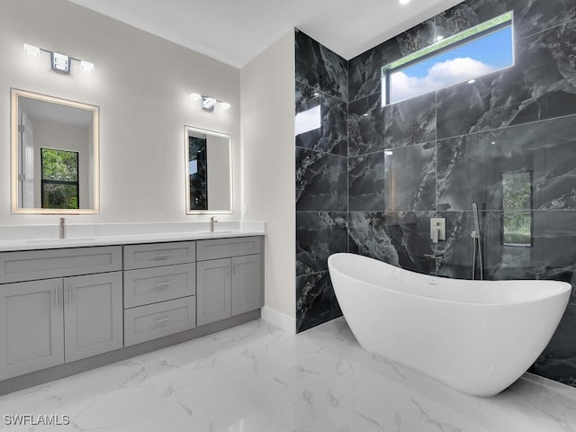 1304 Williams Ave, Lehigh Acres, FL 33972 - bathroom with marble tiled flooring, double vanity, a soaking tub, plenty of natural light, and tile walls