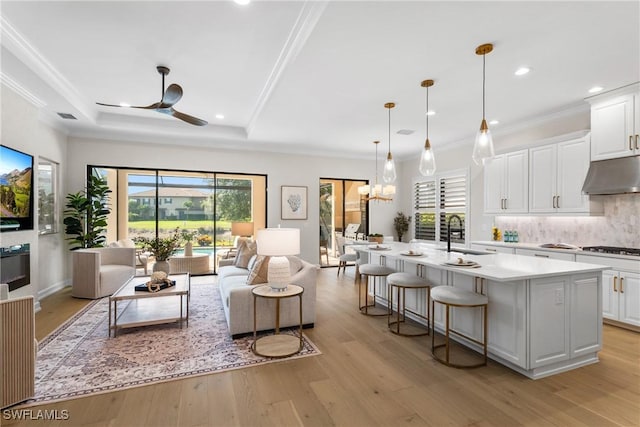 8834 Vaccaro Ct, Naples, FL 34119 - living room with light wood finished floors, plenty of natural light, a ceiling fan, recessed lighting, and a raised ceiling